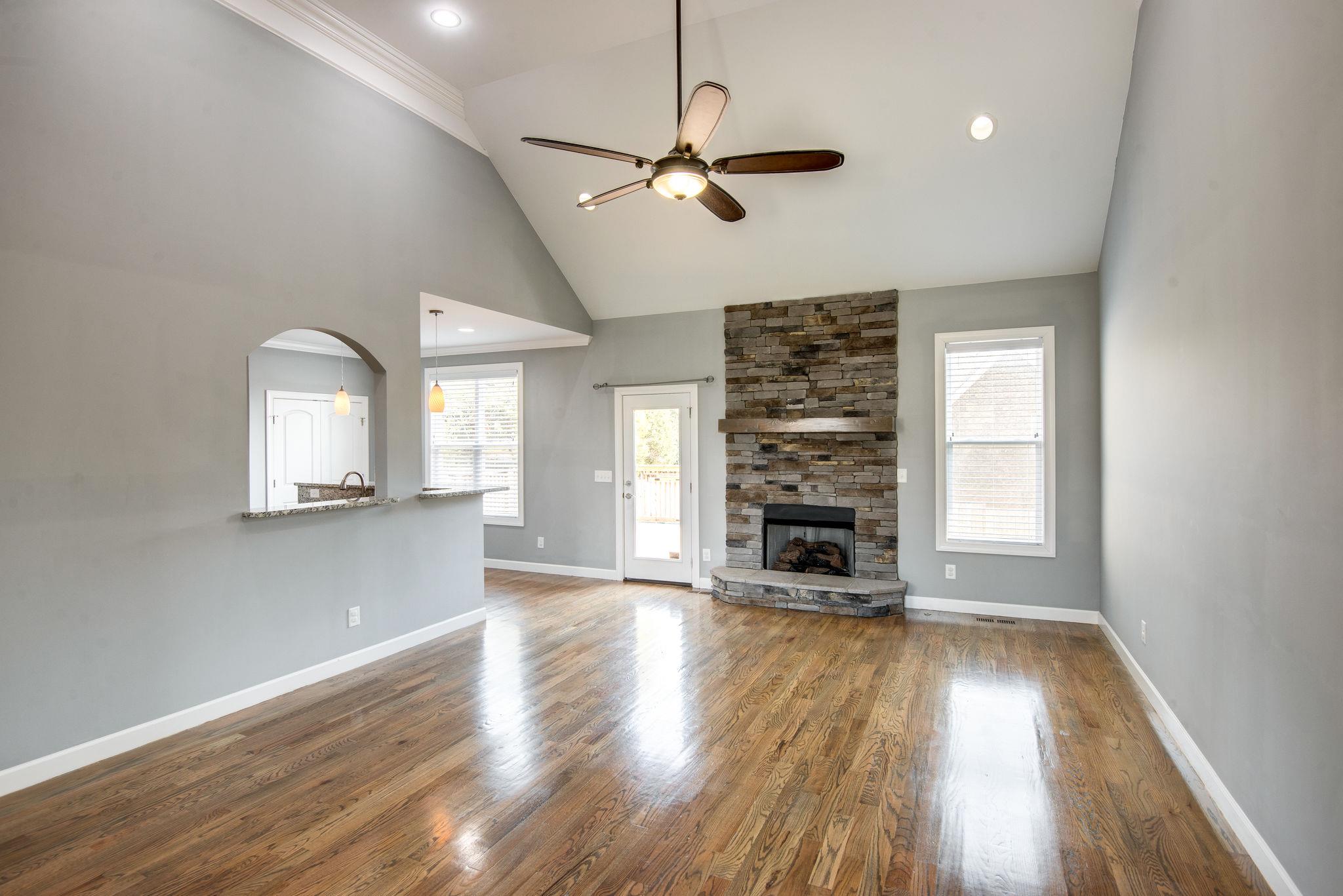 7316 Allans Ridge Lane Fairview, TN 37062 - Photo 3 of 30 an empty room with wooden floor fireplace and windows
