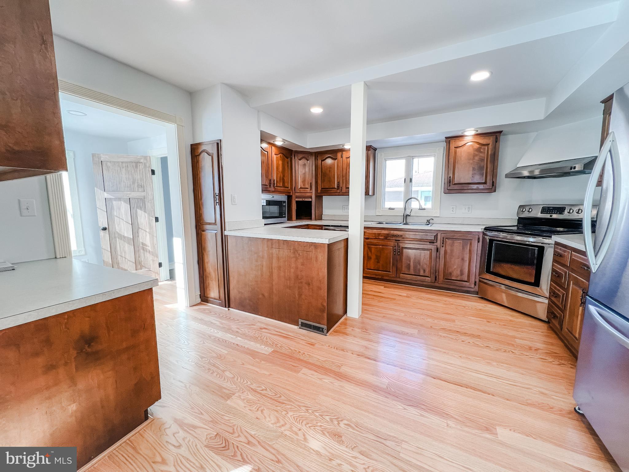 126 South Orange Street Beavertown, PA 17813 - Photo 4 of 25 a large kitchen with stainless steel appliances granite countertop a stove and a wooden floors