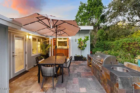a backyard of a house with table and chairs