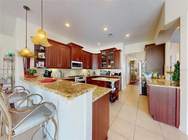 a kitchen with stainless steel appliances granite countertop wooden cabinets sink and stove