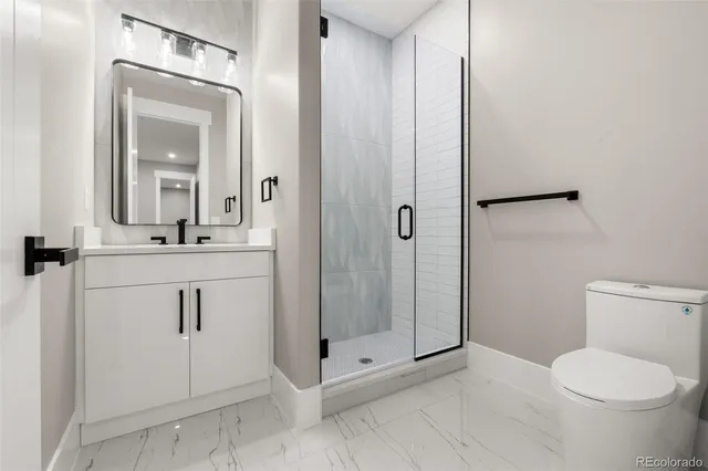 a bathroom with a toilet a sink a mirror and vanity