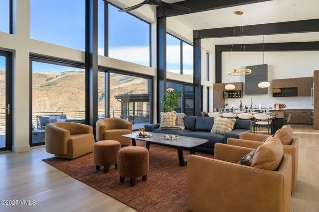 a living room with furniture and floor to ceiling windows