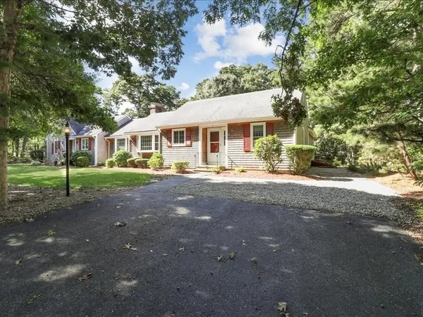 a front view of a house with a yard and trees
