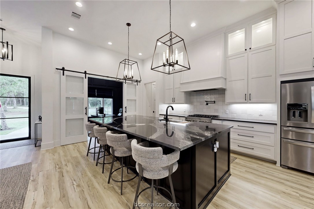 1629 Sawmill Road Franklin, TX 77856 - Photo 5 of 47 a kitchen with kitchen island stainless steel appliances a table chairs refrigerator and microwave