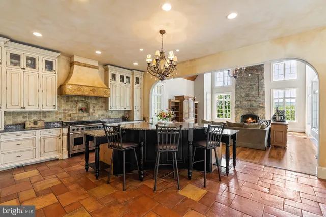 a view of a dining room and livingroom with furniture wooden floor a chandelier