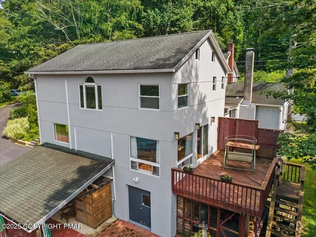 an aerial view of residential house with outdoor space and trees all around