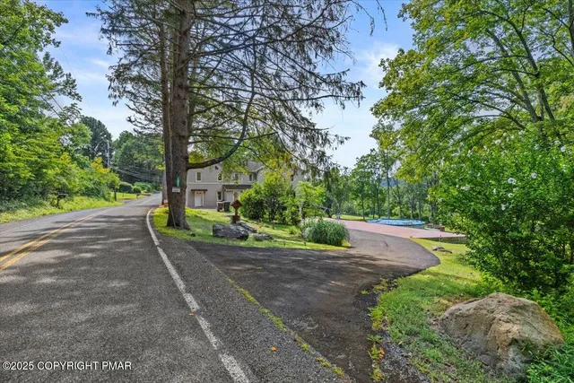 a view of a house with pool and a yard
