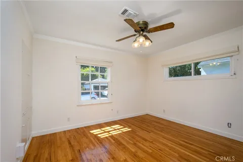 a view of a big room with wooden floor and windows