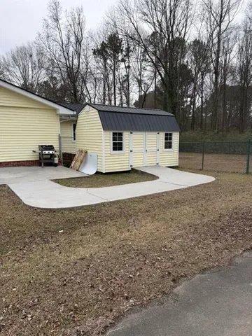a view of a house with a yard and large tree