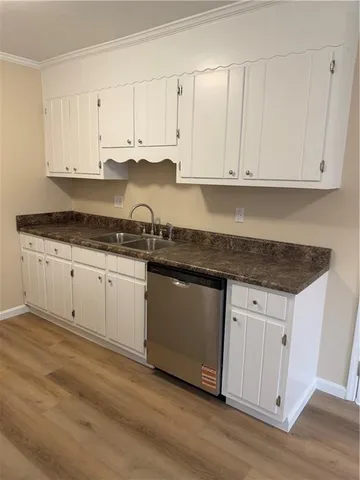 a white kitchen with granite countertop stainless steel appliances