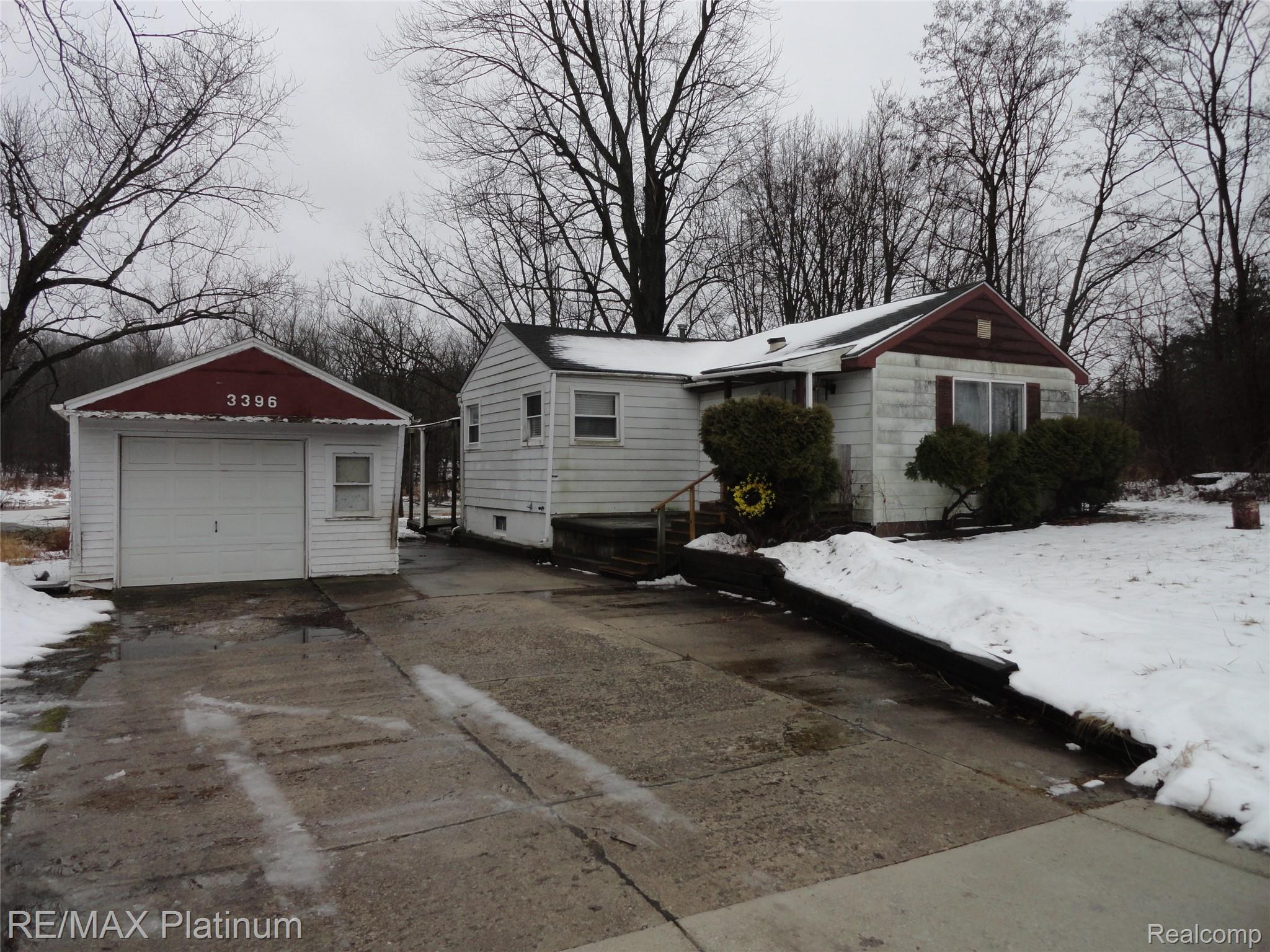 3396 East Baldwin Road Grand Blanc, MI 48439 - Photo 16 of 16 Snow covered property with an outbuilding, concrete driveway, and a detached garage