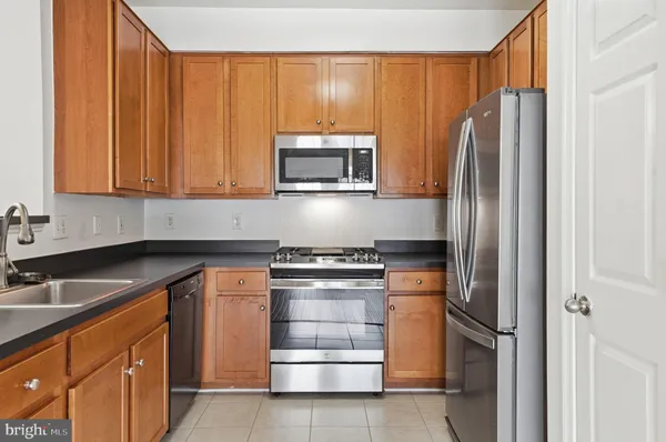 a kitchen with stainless steel appliances granite countertop a stove microwave and refrigerator
