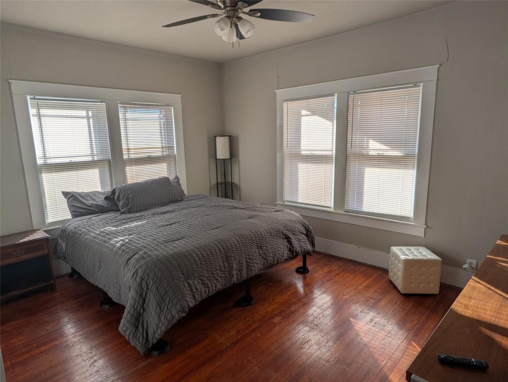 849 Grape Street Abilene, TX 79601 - Photo 6 of 11 a bedroom with a bed and wooden floor