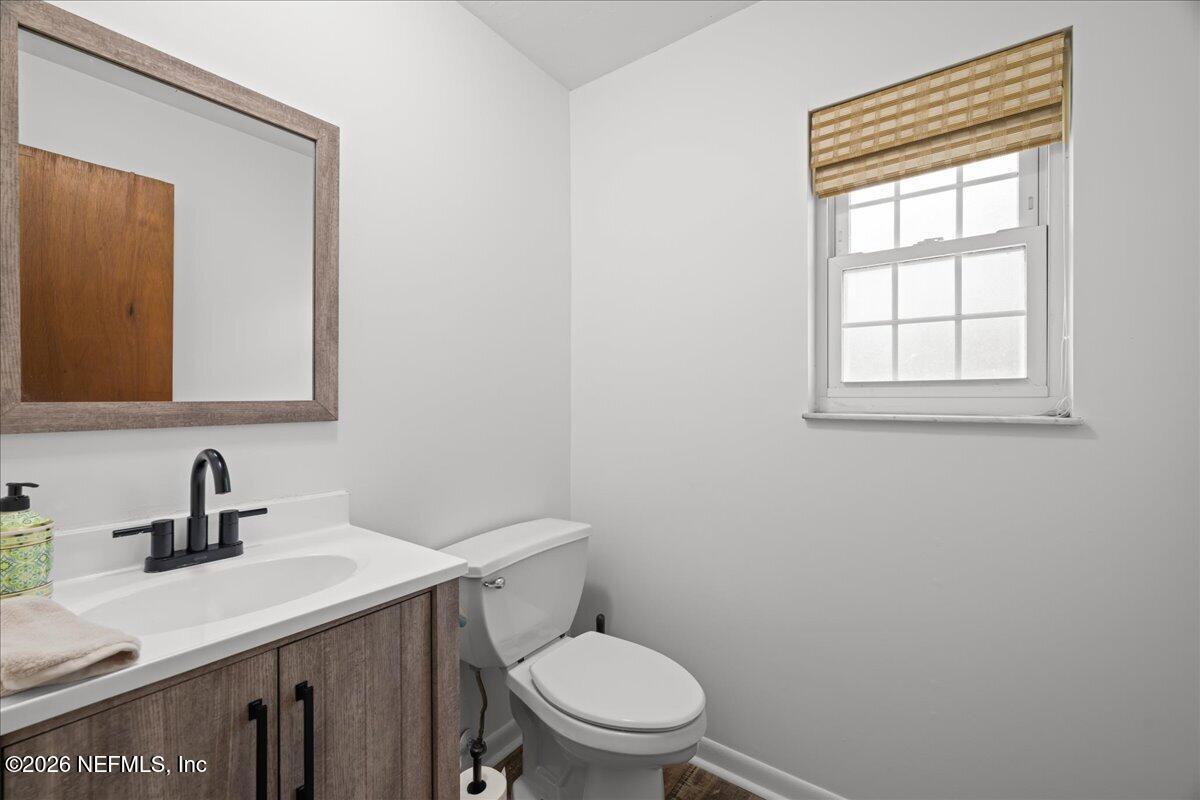 986 Highway 20 Interlachen, FL 32148 - Photo 10 of 53 a bathroom with a toilet a sink a mirror and vanity