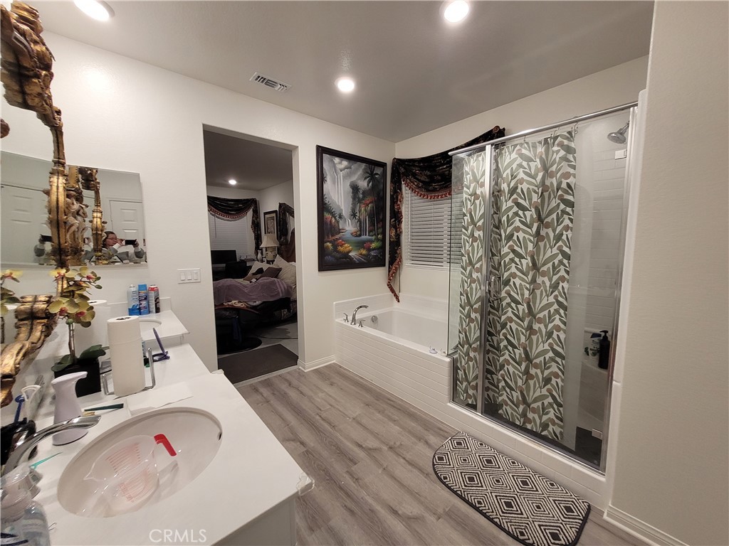7561 Baerss Road Riverside, CA 92507 - Photo 18 of 27 a bathroom with a bathtub sink and mirror