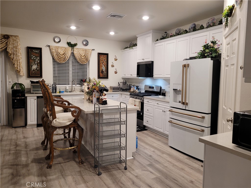 7561 Baerss Road Riverside, CA 92507 - Photo 10 of 27 a kitchen with stainless steel appliances kitchen island granite countertop a refrigerator and a stove top oven