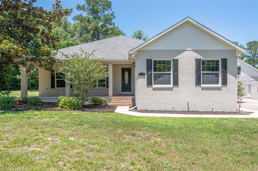 4735 Southeast 112th Street Road Belleview, FL 34420 - Photo 2 of 73 a front view of a house with a yard and garage