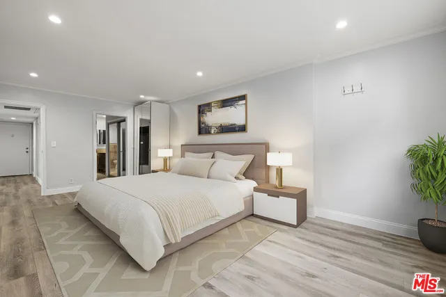 a bedroom with a large bed and potted plant