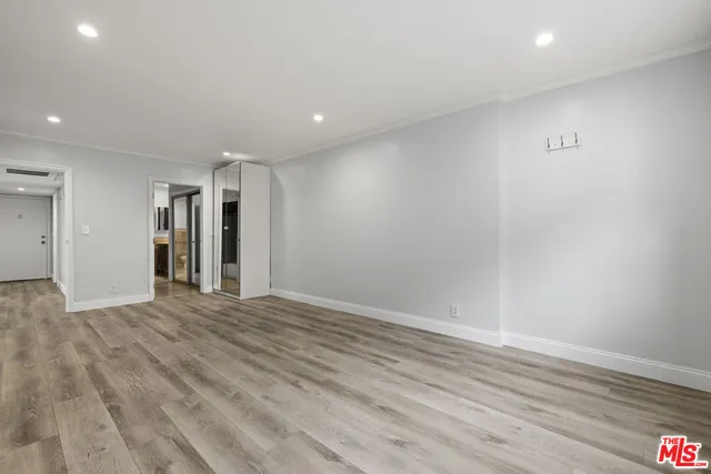 a view of empty room with wooden floor