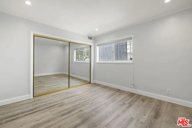 an empty room with wooden floor and window