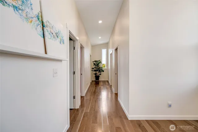 a view of a hallway with wooden floor and staircase