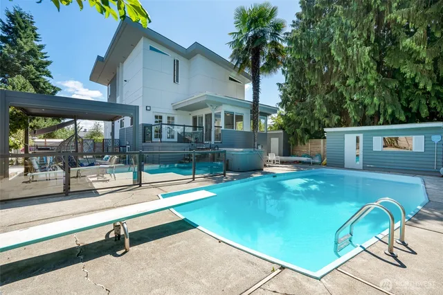 a view of a house with pool and a yard