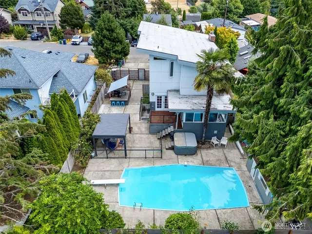 an aerial view of residential houses with outdoor space and trees all around