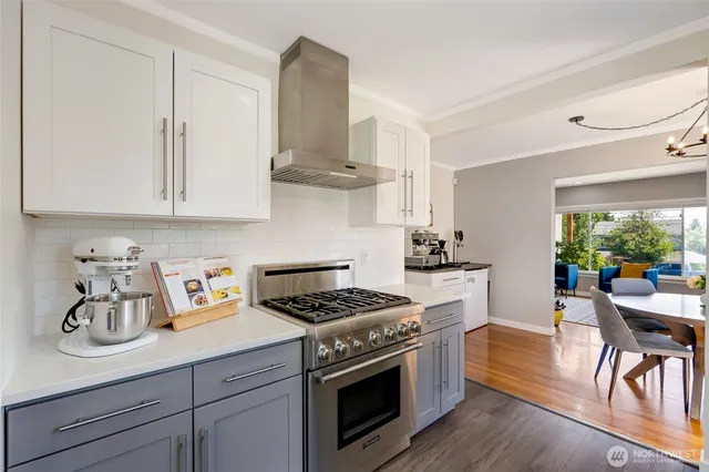 a kitchen with stainless steel appliances a white stove top oven and a white cabinets