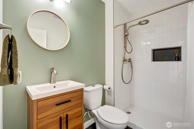 a bathroom with a toilet sink shower and mirror