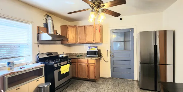 a kitchen with stainless steel appliances granite countertop a refrigerator a stove and a sink