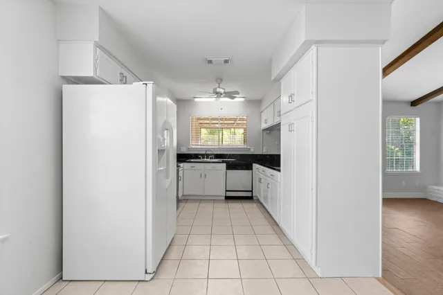 a kitchen with a refrigerator a sink and cabinets