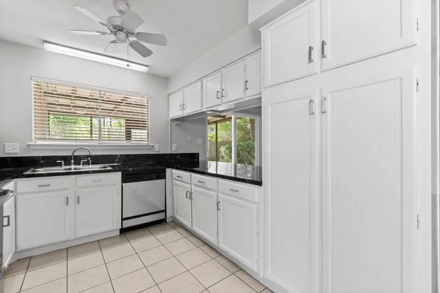 a kitchen with granite countertop white cabinets white appliances with a sink and dishwasher