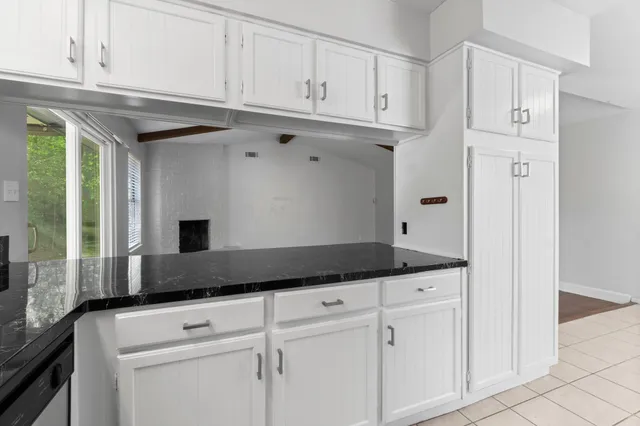 a kitchen with granite countertop white cabinets and white appliances