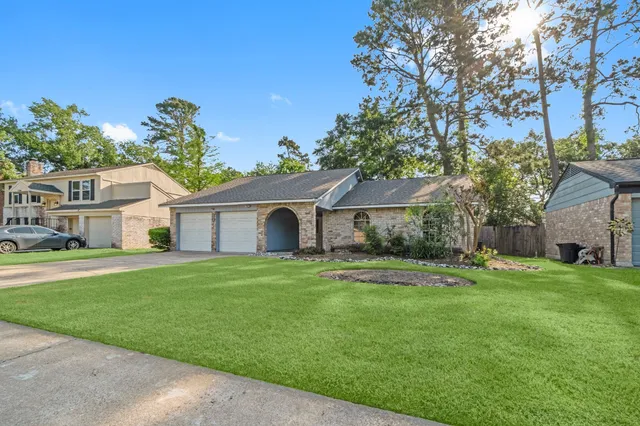 a front view of a house with a yard and trees
