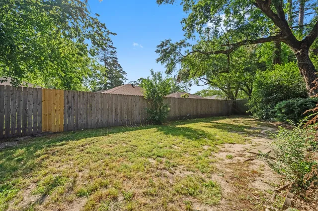 a view of garden with wooden fence
