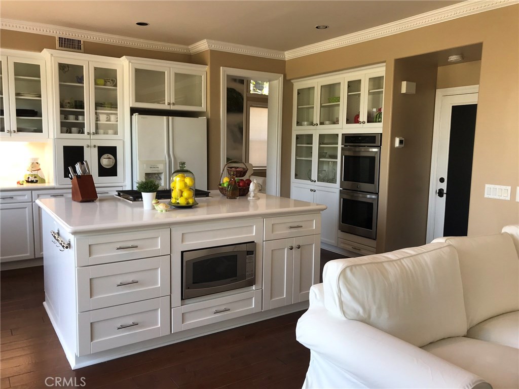 12823 Maxwell Drive Tustin, CA 92782 - Photo 22 of 25 a living room with stainless steel appliances kitchen island granite countertop a stove and a sink