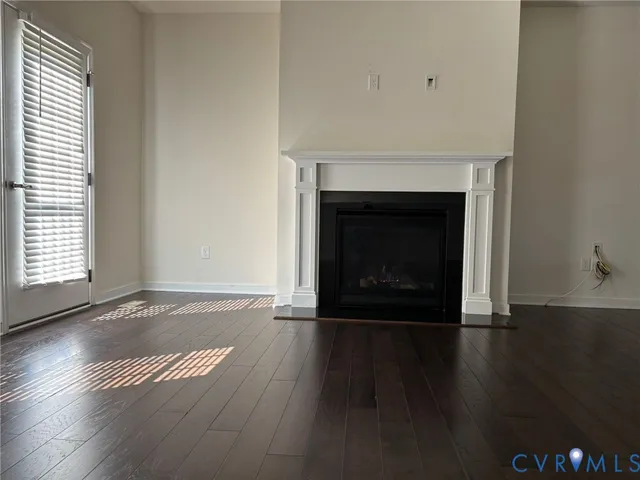 an empty room with wooden floor and fireplace