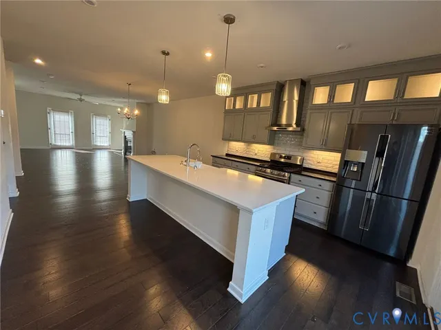 a kitchen with stainless steel appliances granite countertop a sink a stove and a refrigerator