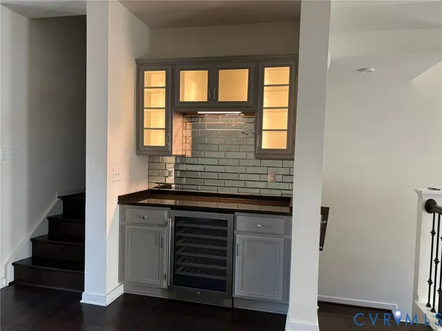 a kitchen with granite countertop white cabinets and wooden floor