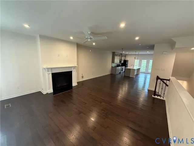 a view of empty room with wooden floor and fireplace