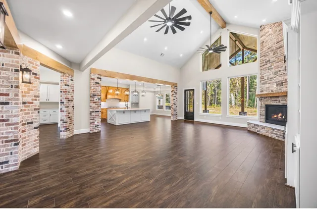 a view of an empty room with window and wooden floor