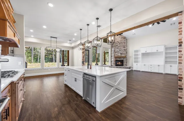 a large kitchen with stainless steel appliances granite countertop a large stove a sink dishwasher and a wooden floor