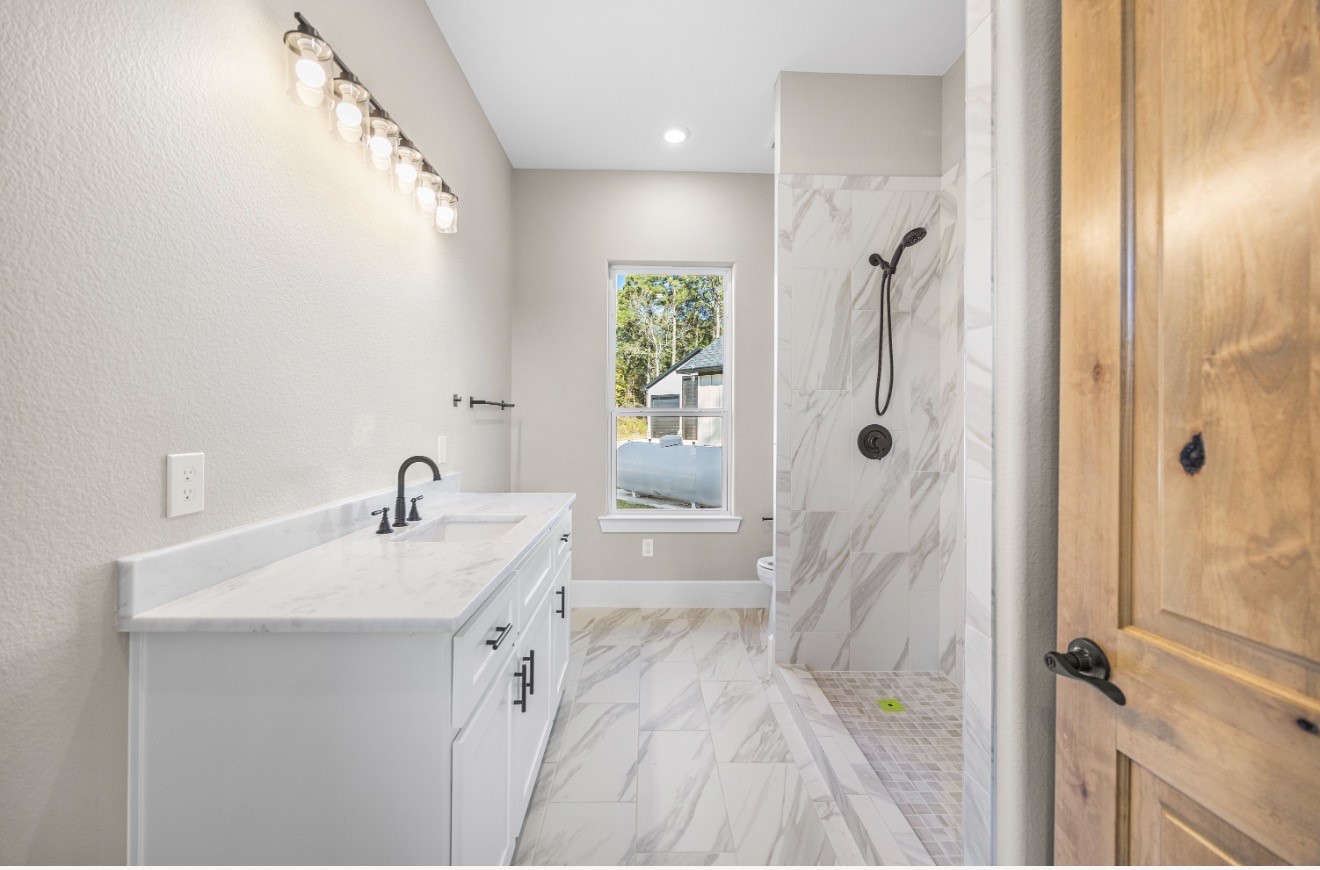 41 Pausel Road Huntsville, TX 77340 - Photo 38 of 41 a bathroom with a sink a toilet a mirror and shower