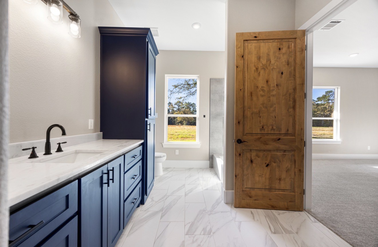 41 Pausel Road Huntsville, TX 77340 - Photo 41 of 41 a en suite bathroom with a granite countertop sink and a mirror