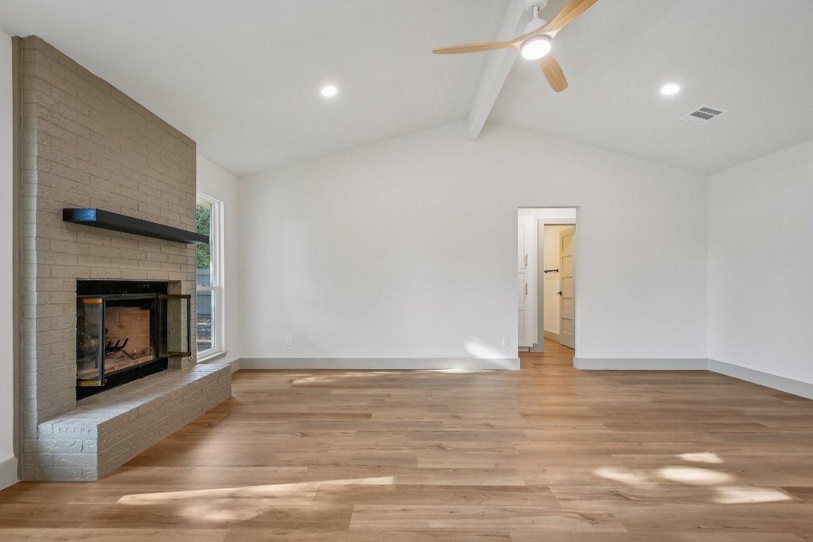 417 Oakridge Pass Cedar Park, TX 78613 - Photo 6 of 33 a view of an empty room with wooden floor fireplace and a window