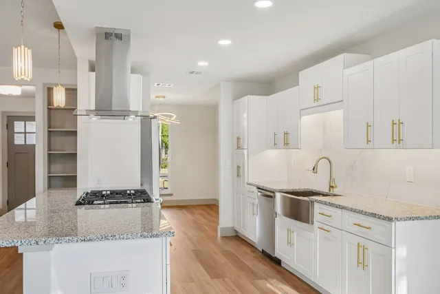 a kitchen with stainless steel appliances granite countertop a sink and a refrigerator