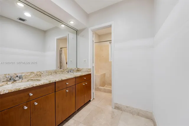 a bathroom with a granite countertop sink and a mirror