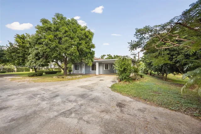 a view of house with outdoor space and trees