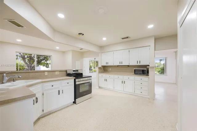 a large white kitchen with cabinets