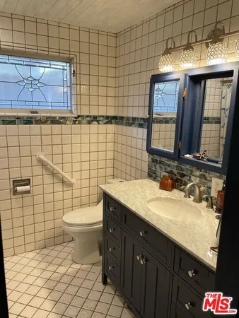 a bathroom with a toilet sink vanity and mirror